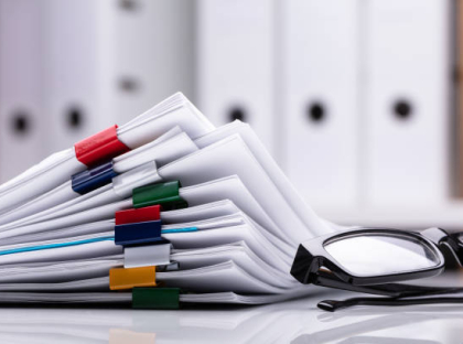 Stacked Documents With Colorful Paperclips And Eyeglasses